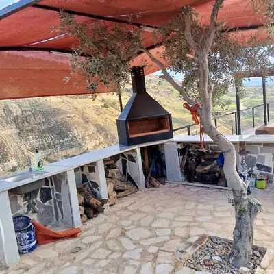 a outdoor grill with a tree in front of it at منتجع ومزرعة برجيل السد in Ballās