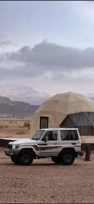 a white truck parked in front of a yurt at مخيم جمال الطبيعه in Wadi Rum