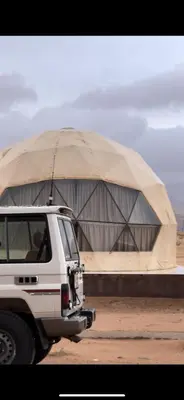 a white truck parked in front of a tent at مخيم جمال الطبيعه in Wadi Rum