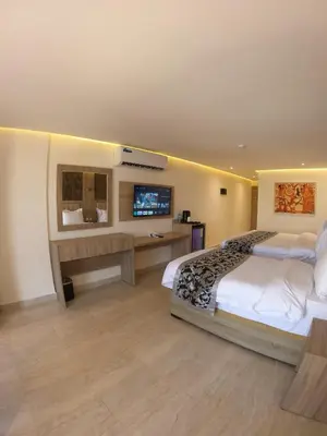 a bedroom with a large bed and a television at Grand Season Hotel in Aqaba