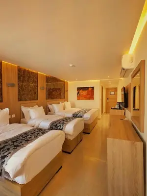a hotel room with three beds in it at Grand Season Hotel in Aqaba