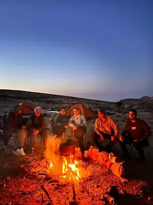 a group of people sitting around a fire at Dana Hiking Camp - Dana Nature Reserve in Dana
