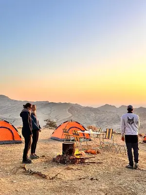 a group of people standing next to tents in the desert at Dana Hiking Camp - Dana Nature Reserve in Dana