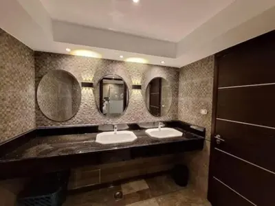 a bathroom with two sinks and two mirrors at LINCON inn in Aqaba