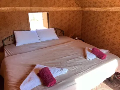 a bed in a room with two pillows on it at Wanderlust Jordan Camp in Wadi Rum