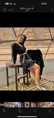a woman in a black dress sitting in a chair at Rum plaza camp in Wadi Rum
