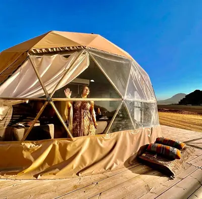 a woman is standing inside of a tent at Rum plaza camp in Wadi Rum