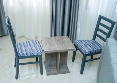 a wooden table and two chairs next to a couch at Gardens Complex in Amman