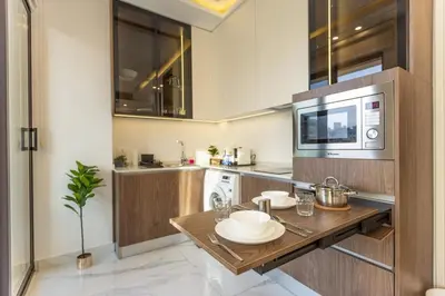 a kitchen with a wooden table and a microwave at Shamsi Apartments 222 in Amman