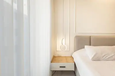 a bedroom with a bed and a nightstand next to a window at Shamsi Apartments 222 in Amman