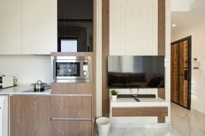 a kitchen with a microwave and a television on a counter at Shamsi Apartments 222 in Amman