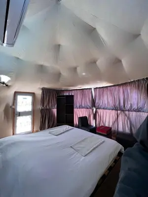 a bedroom with a large white bed in a tent at calm Rum in Wadi Rum
