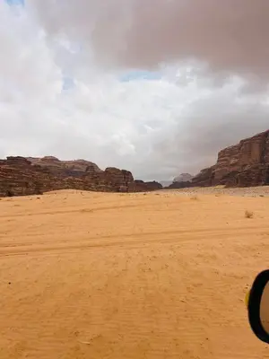 a view of the desert with mountains in the background at calm Rum in Wadi Rum