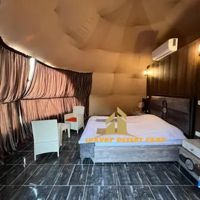 a room with a bed and two chairs in it at Luxury Desert Camp in Disah