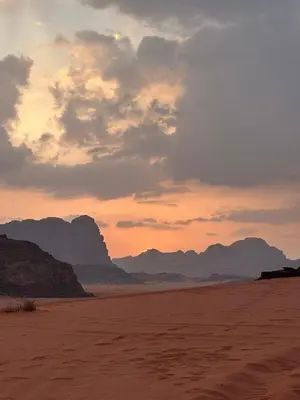 a sunset in the desert with mountains in the background at Luxury Desert Camp in Disah