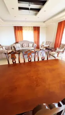 a living room with a wooden table and chairs at Badr in Amman