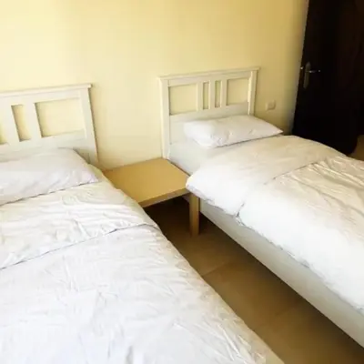 two beds sitting next to each other in a room at Badr in Amman