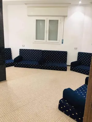 a living room with a blue couch and a window at almiddle house in Kafr Asad