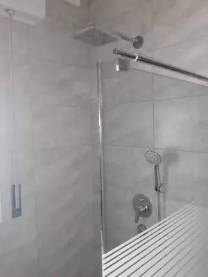 a shower with a glass door in a bathroom at almiddle house in Kafr Asad