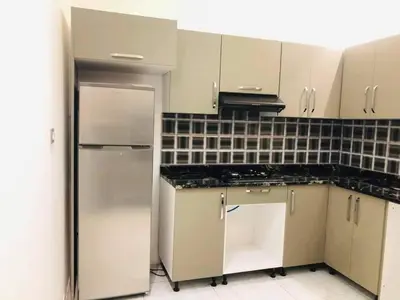 a kitchen with white cabinets and a stainless steel refrigerator at almiddle house in Kafr Asad