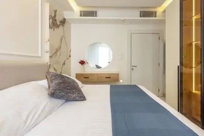 a bedroom with a large white bed with a mirror at Shamsi Apartments 329 in Amman