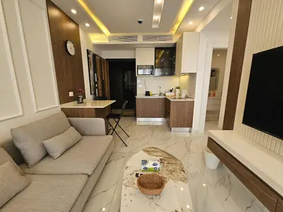 a living room with a couch and a kitchen at Shamsi Apartments 009 in Amman