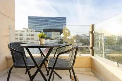 a table and two chairs on a balcony with a window at Shamsi Apartments 436 in Amman