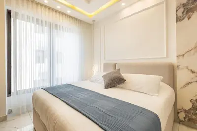 a bedroom with a bed and a large window at Shamsi Apartments 436 in Amman