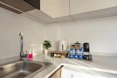 a kitchen counter with a sink and some bottles of water at Shamsi Apartments 436 in Amman