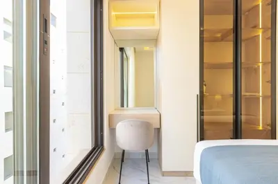 a bedroom with a bed and a chair next to a window at Shamsi Apartments 437 in Amman