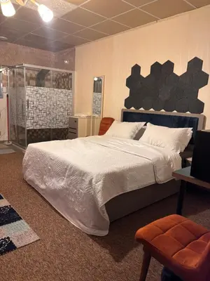 a bedroom with a large bed and a chair at DeadSea studio in Sowayma