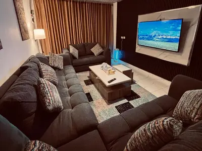 a living room with a couch and a flat screen tv at DeadSea studio in Sowayma
