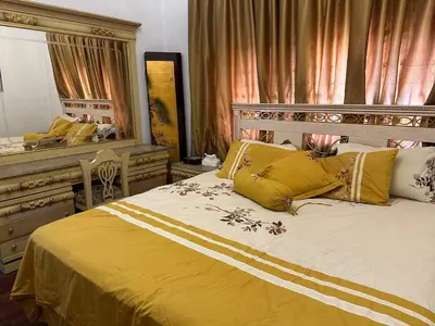a bedroom with a large bed with yellow pillows at شقة مفروشة في حي نزال Furnished Apartment Hay Nazzal in Amman