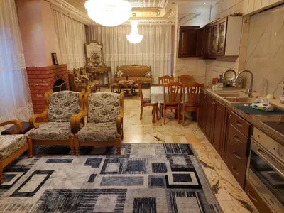 a kitchen and dining room with a table and chairs at شقة مفروشة في البنيات - بالقرب من جامعة البتراء in Amman