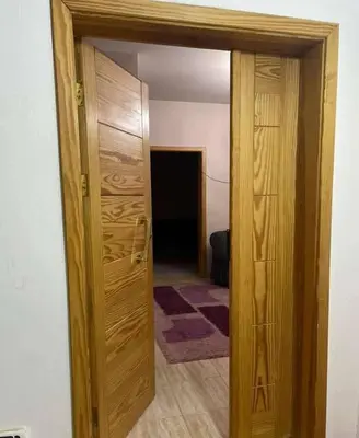 an open wooden door in a room with a hallway at kazbon House in Al Hāshimīyah
