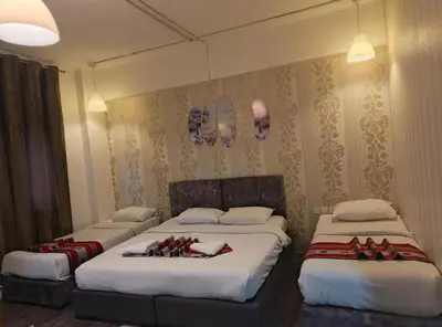 two beds in a hotel room with red and white blankets at Gate Inn in Amman