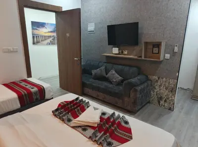 a hotel room with a couch and a tv at Gate Inn in Amman