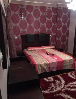 a bedroom with a bed with a red comforter at birds House in Jerash