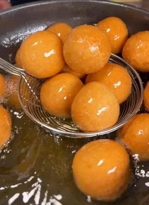 a pile of tangerines sitting in a bowl of water at birds House in Jerash