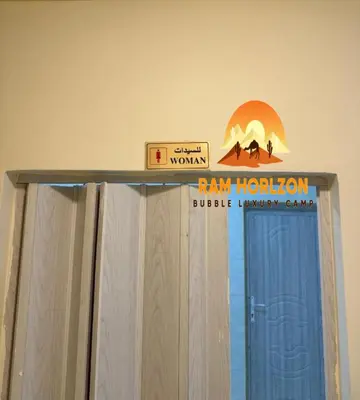 a sign on top of a shower curtain in a room at RAM HORlZON LUXURY CAMP in Wadi Rum