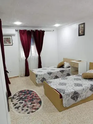 a bedroom with two beds and a rug at 909 apartment in Amman