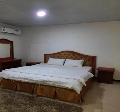 a bedroom with a large bed with white sheets at asfouer Hostel in Muqbilah