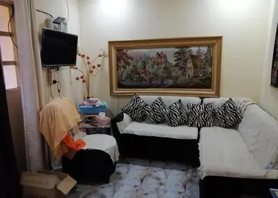 a living room with a couch and a television at asfouer Hostel in Muqbilah