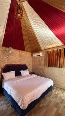 a bedroom with a large bed with a red ceiling at Nova Luxury Camp in Wadi Rum