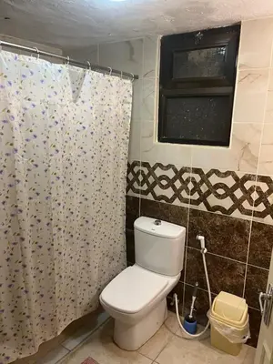 a bathroom with a toilet and a shower curtain at University Castle in Amman
