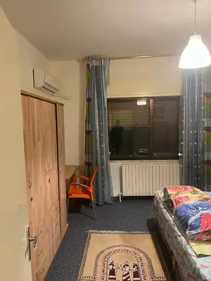 a bedroom with a bed and a desk and a window at University Castle in Amman