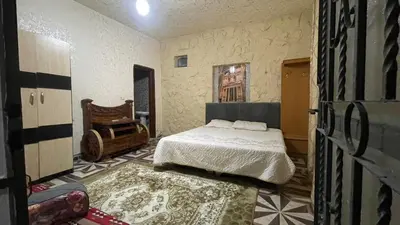 a bedroom with a bed and a chair in it at zainab bedouin house in Petra