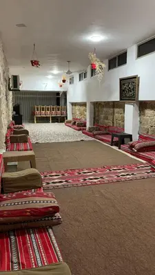 a large room with rows of tables and rugs at zainab bedouin house in Petra