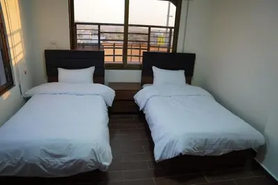 two beds in a small room with a window at LeRose Villa in Ash Shāghūr