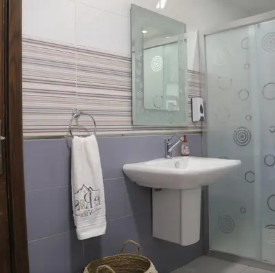 a bathroom with a sink and a mirror at LeRose Villa in Ash Shāghūr
